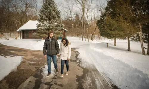 Un couple marche sur un chemin entouré de neige