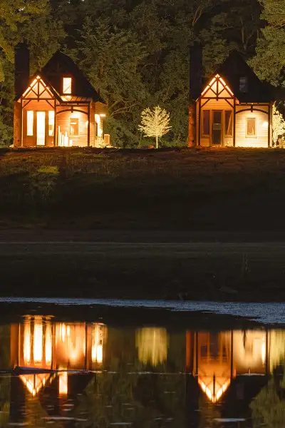 Quatre cabines éclairées la nuit, se reflétant dans l'eau