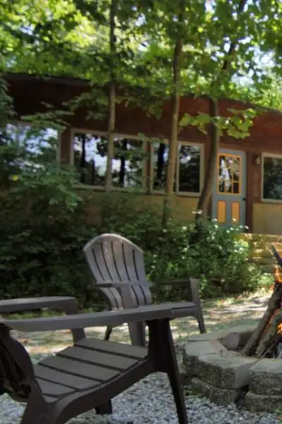 une maison avec des chaises et un foyer à l'extérieur