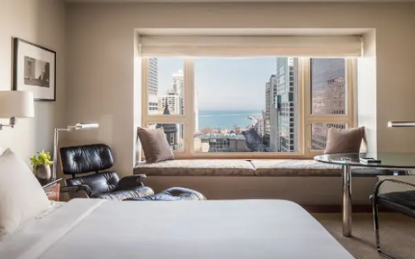 Chambre d'hôtel avec une grande fenêtre donnant sur la ville.