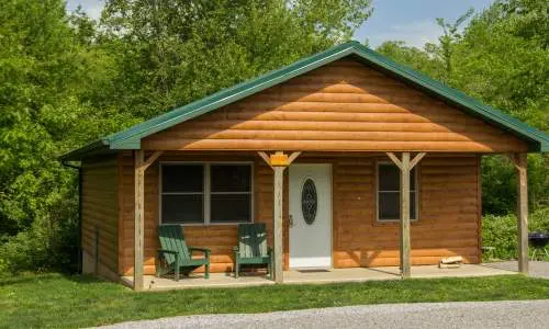 L'extérieur d'une cabane en bois entourée de verdure