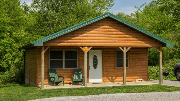 L'extérieur d'une cabane en bois entourée de verdure