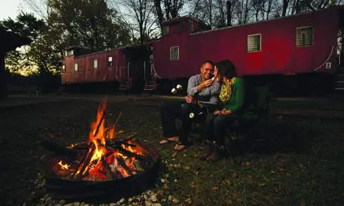 Un couple mange près d'un feu de camp