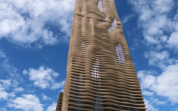 L'extérieur de l'Aqua Tower à Chicago, sur fond de ciel bleu avec des nuages.
