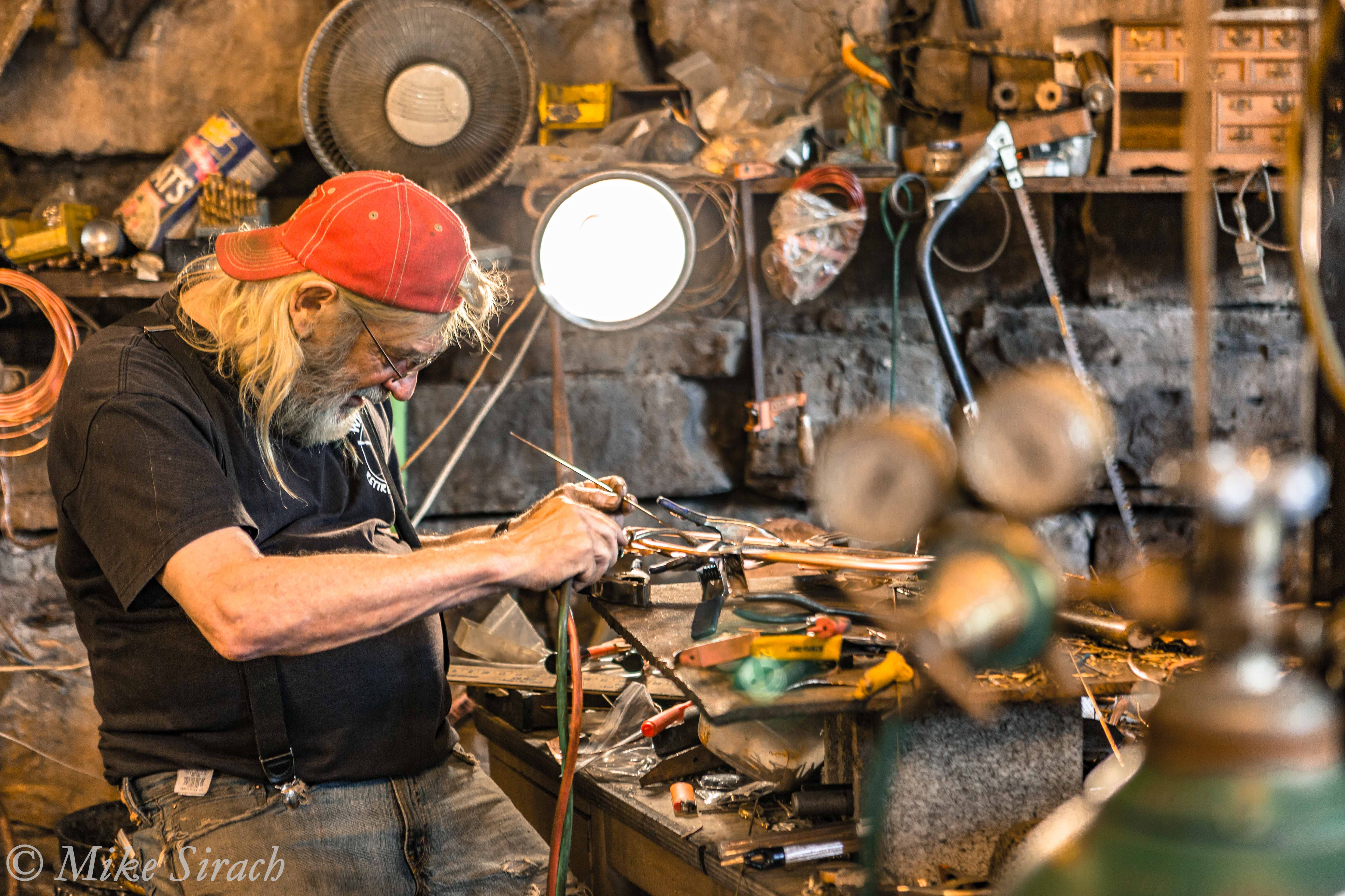 Un artisan au travail dans l'atelier des Rain Maker Studios à Makanda