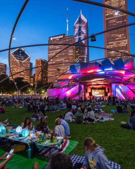 Une foule s'est rassemblée sur la pelouse pour assister à un concert en soirée au Millennium Park de Chicago.