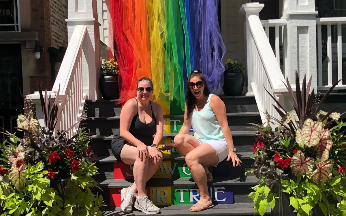 Des filles devant le drapeau de la fierté.