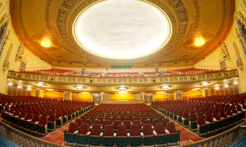 Un auditorium de théâtre orné à deux niveaux, vu de la scène