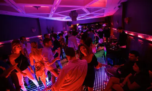 Des clients dansent sur une piste de danse éclairée