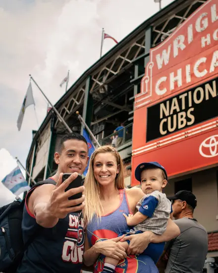 Famille posant pour une photo devant un stade