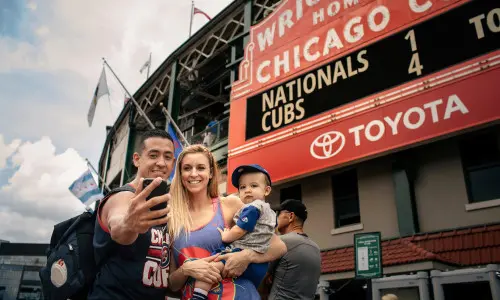 Famille posant pour une photo devant un stade 