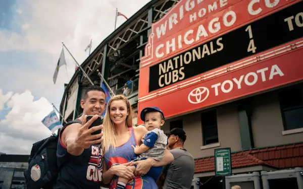 Famille posant pour une photo devant un stade 