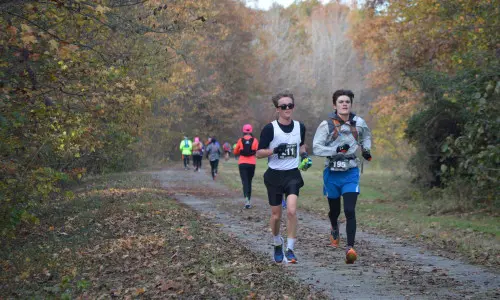 Des coureurs s'élancent sur une piste d'athlétisme à l'automne