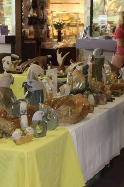 Une femme regarde des œuvres d'art sur un marché de vacances