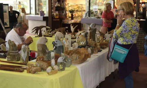 Une femme regarde des œuvres d'art sur un marché de vacances