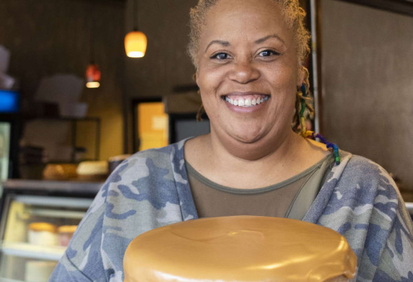 Une femme souriante tenant un gâteau