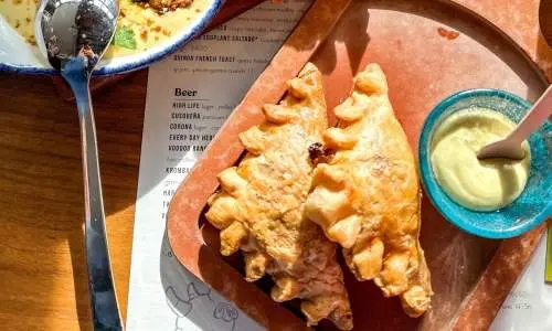 Empanadas et autres aliments sur une table au restaurant Cabra à Chicago