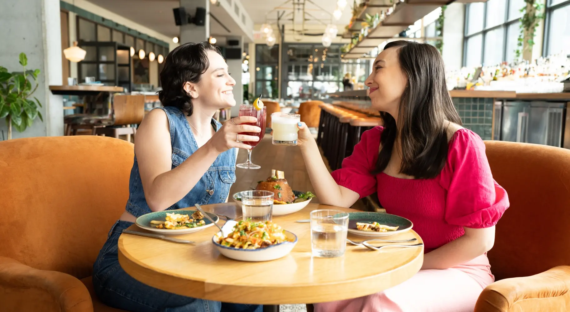 Deux personnes trinquant à une petite table au Cabra, un bar sur le toit.