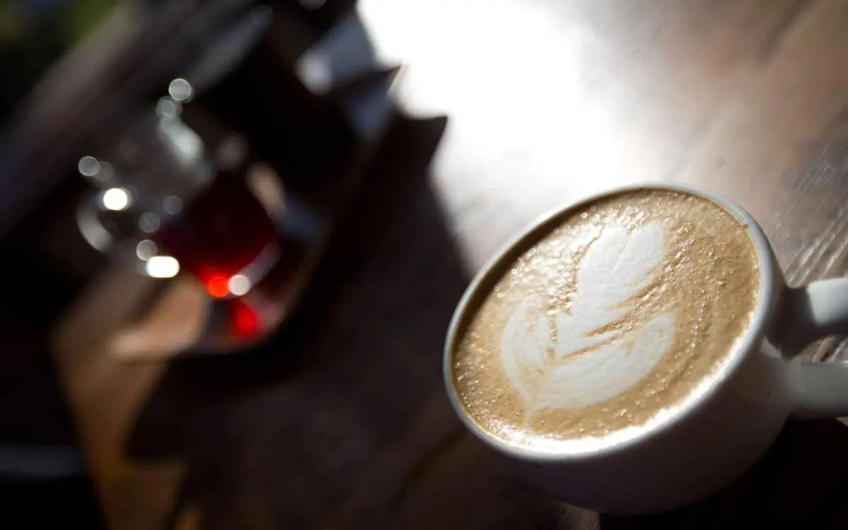 Une tasse de café avec la forme parfaite d'une feuille de café latté réalisée à partir de la mousse de lait.