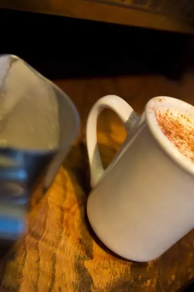 Une tasse à café remplie à ras bord d'un café au lait épicé à la citrouille.