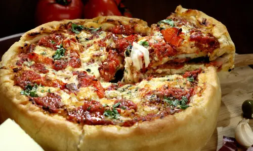 Une part de pizza à pâte épaisse servie