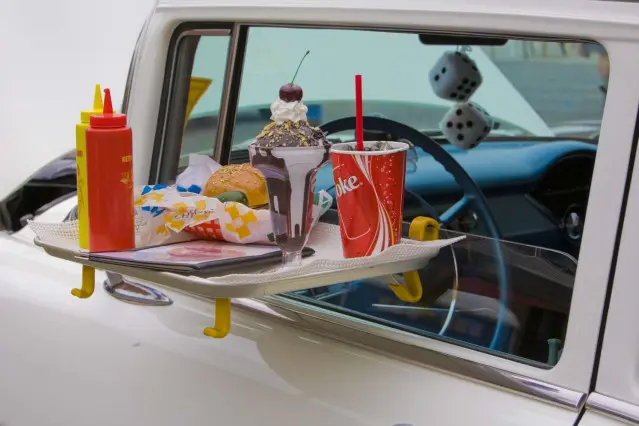 Nourriture sur un plateau fixé à la fenêtre d'une voiture