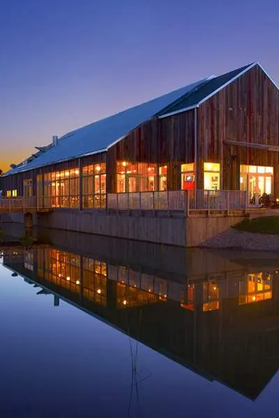 Une photo du grill Firefly au coucher du soleil avec le lac reflétant le bâtiment.