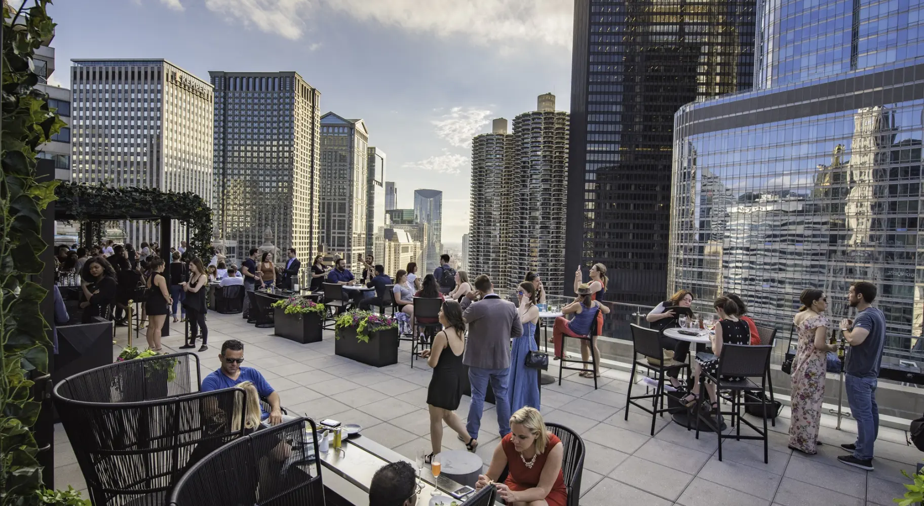 Des personnes se sont rassemblées dans un bar sur le toit, au milieu des gratte-ciel.