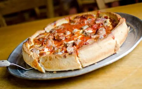 Une pizza à pâte épaisse sur une assiette de Papa Dels.