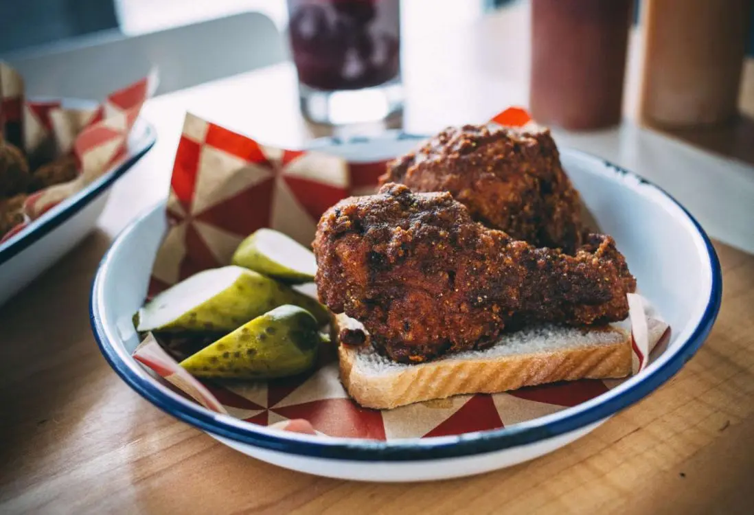Deux pilons de poulet et des cornichons sur un morceau de pain