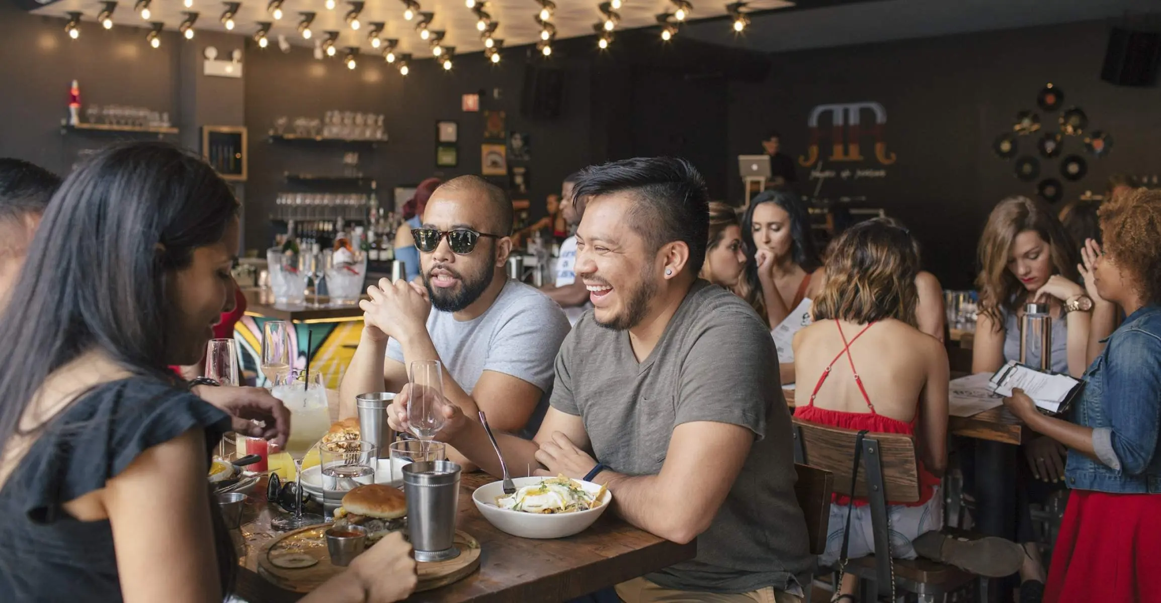 Trois amis prenant un brunch dans un bar-restaurant très fréquenté