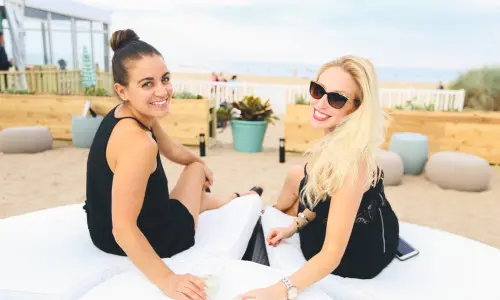 Deux femmes buvant un verre sur une chaise longue de plage