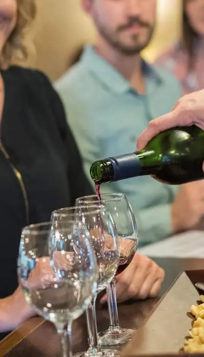 Verser du vin dans des verres devant une femme 