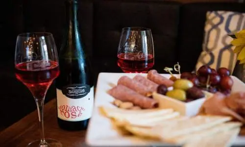 Un plateau de fromage et quelques verres de vin posés sur une table