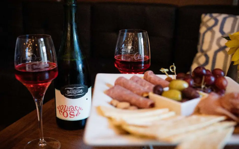 Un plateau de fromage et quelques verres de vin posés sur une table