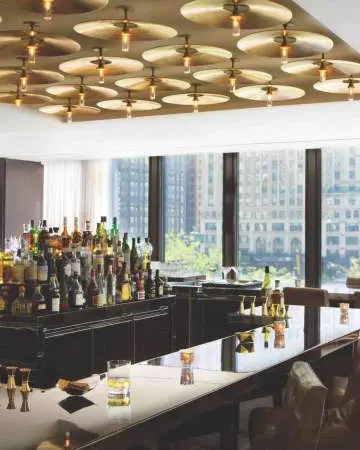 Intérieur d'un bar avec de nombreuses fenêtres donnant sur la ville.