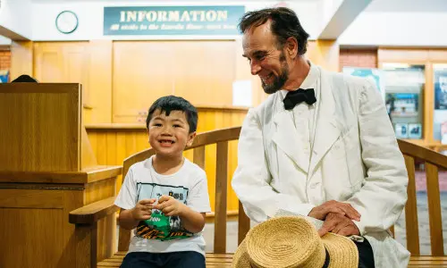 Un garçon et un homme assis sur une chaise dans une pièce