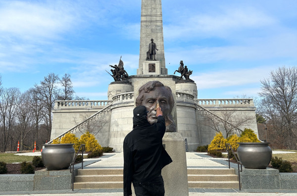 Sherman Dilla Thomas frotte le buste en laiton d'Abraham Lincoln sur sa tombe à Springfield.