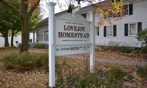 Un panneau blanc pour la propriété des Lovejoy avec des feuilles d'automne autour.