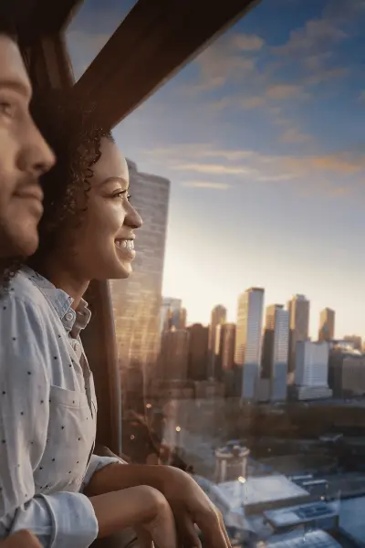 Couple à l'intérieur de la roue du Centenaire pendant le coucher du soleil sur la ville.