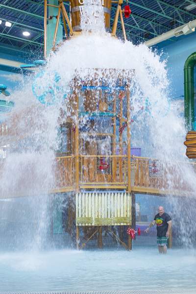 Un seau d'eau basculant sur des enfants jouant dans un parc aquatique