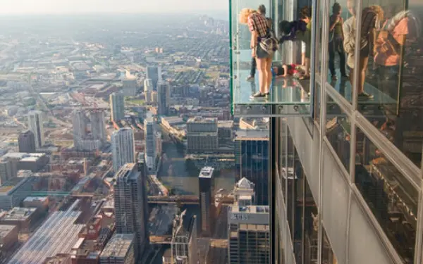 Personnes se tenant dans The Ledge, une boîte en verre surplombant Chicago à la Willis Tower