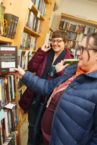 Femmes dans une librairie regardant une étagère de livres