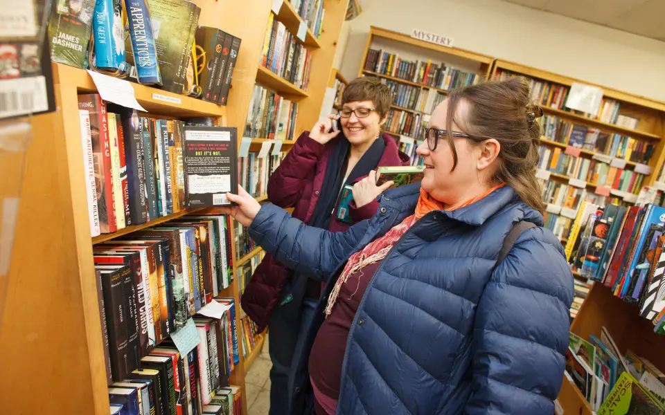 Femmes dans une librairie regardant une étagère de livres