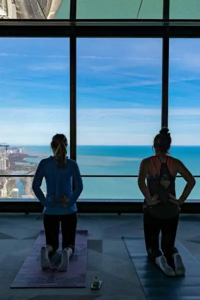 Quatre personnes agenouillées sur des tapis de yoga regardant la côte de Chicago