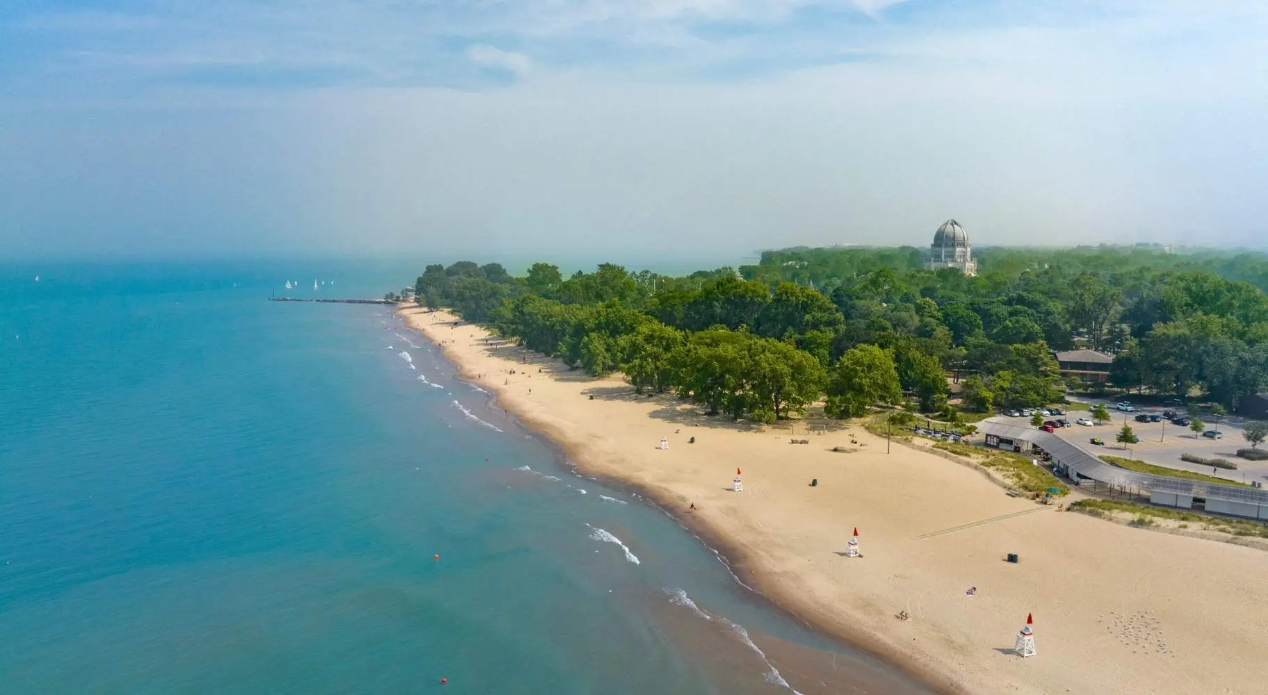 Vue aérienne de plage et d'un littoral, avec des arbres verts en arrière-plan