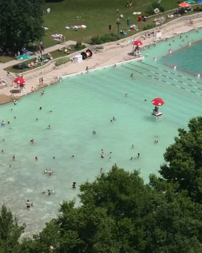 Vue aérienne d'une plage de carrière remblayée, avec des personnes dans l'eau et sur le rivage.