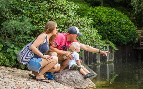 Parents et leur jeune enfant regardant un étang