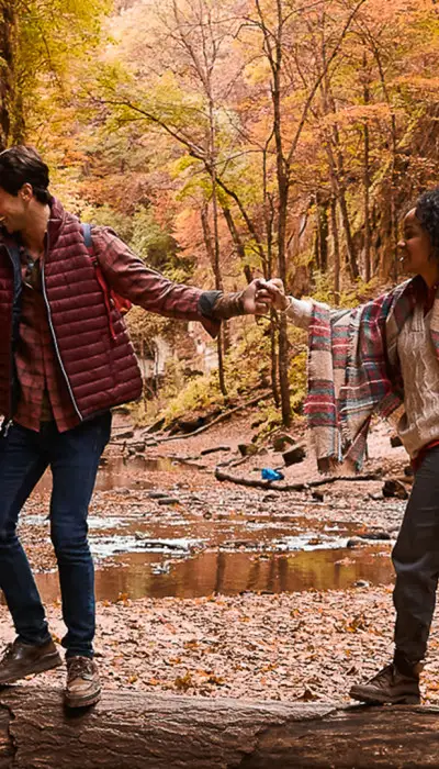 Couple en randonnée dans les bois à l'automne.