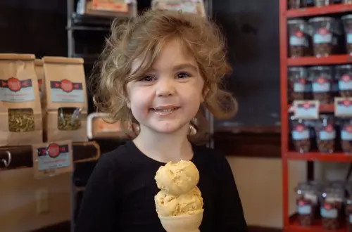 Un jeune enfant savoure un cornet de glace. 